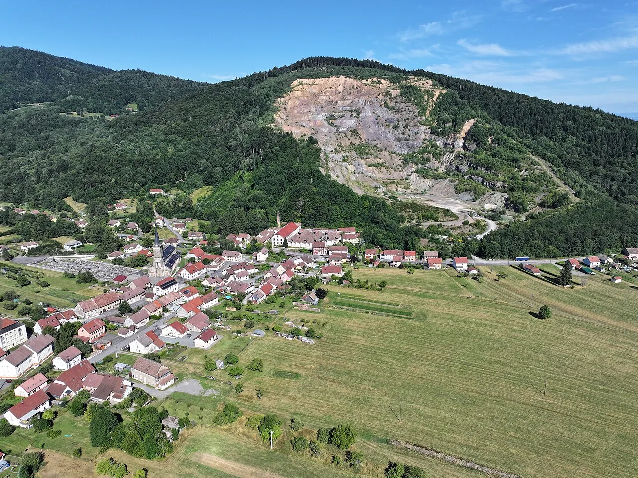 Vue aérienne de Lepuix avec de gauche à droite : le cimetière, l'église, l'ancien tissage Boigeol et l'ancienne carrière-ballastière.